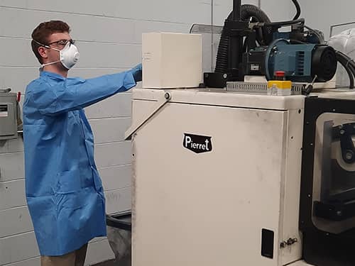 worker chopping fibers with a machine